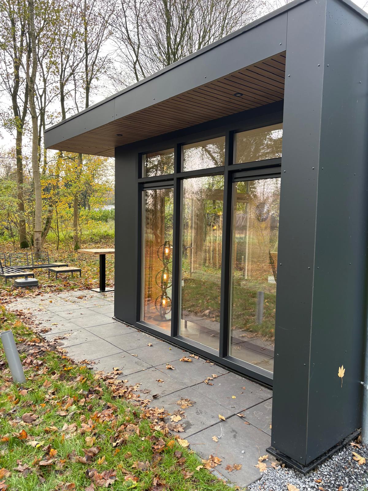 Het overdekte terras met glaspui aan de bosrand
