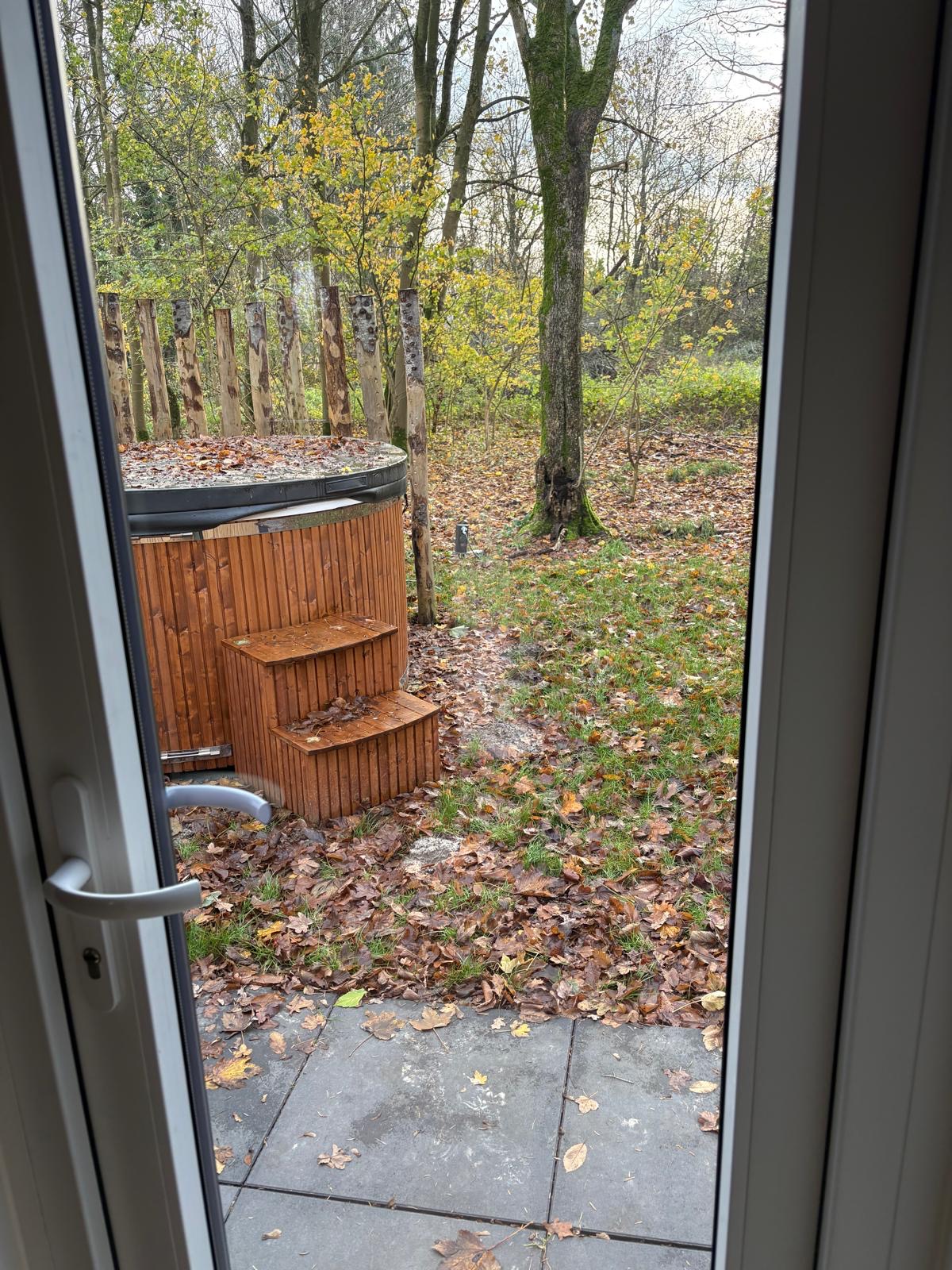 Uitzicht op de houtgestookte hottub vanuit de deuropening
